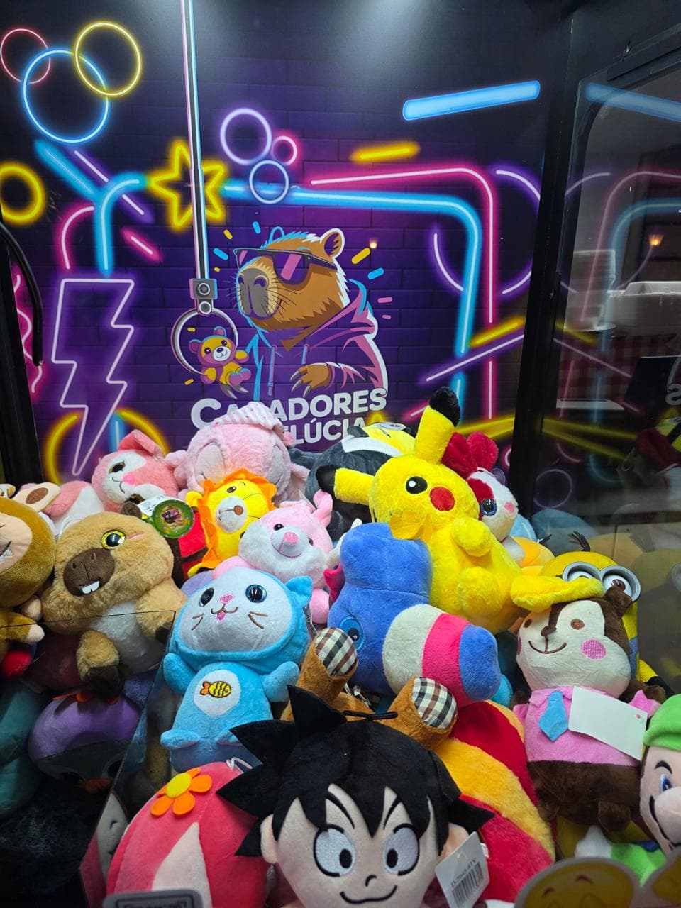 Pelúcias coloridas dentro da máquina com fundo neon